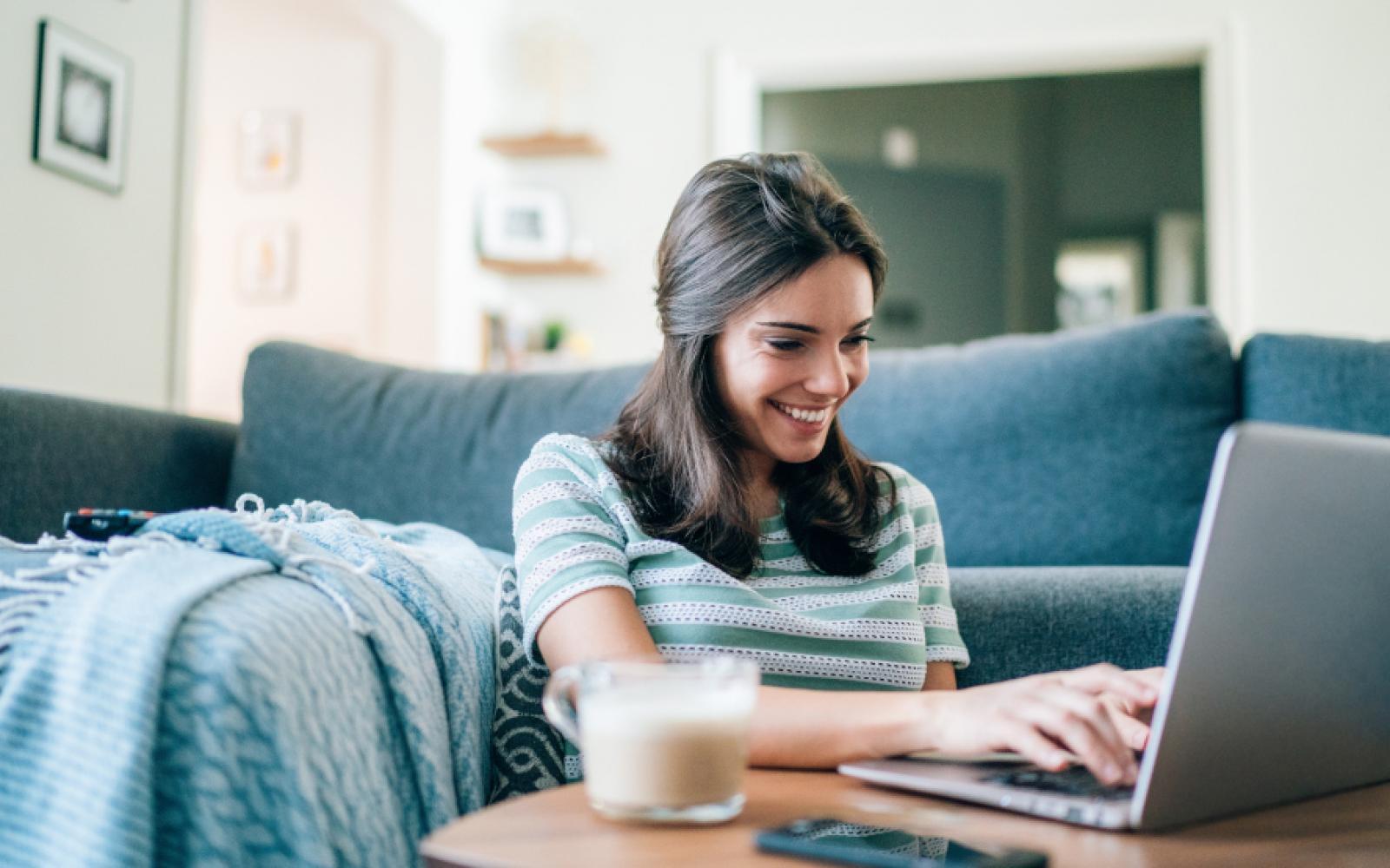 Mujer sonriendo leyendo computadora